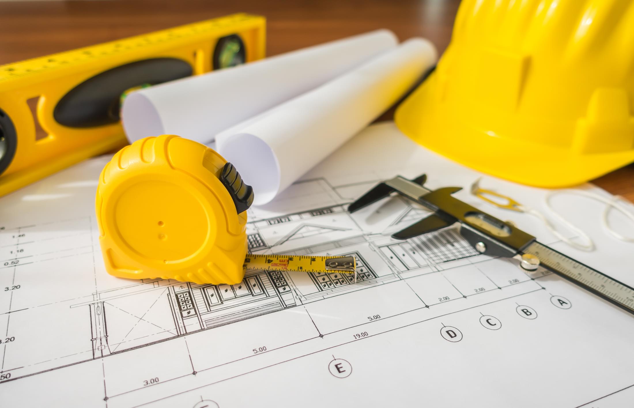 construction plans with yellow helmet drawing tools bluep