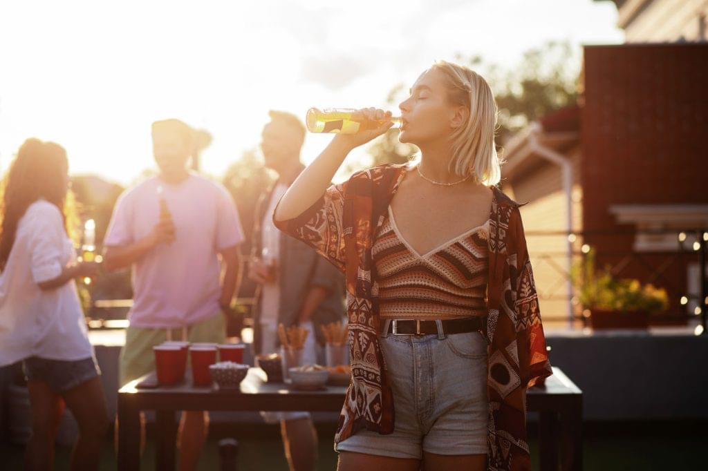 medium shot woman drinking beer party