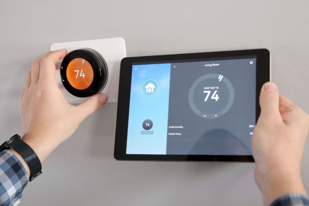 man is adjusting temperature using tablet with smart home app modern living room web